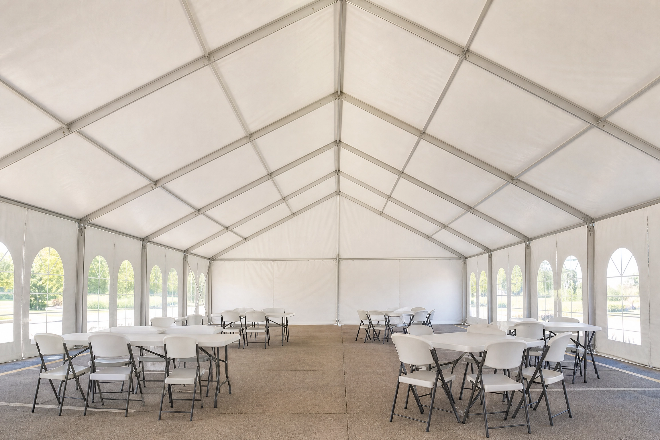 Interior of a white frame tent showing no center poles and open space on concrete