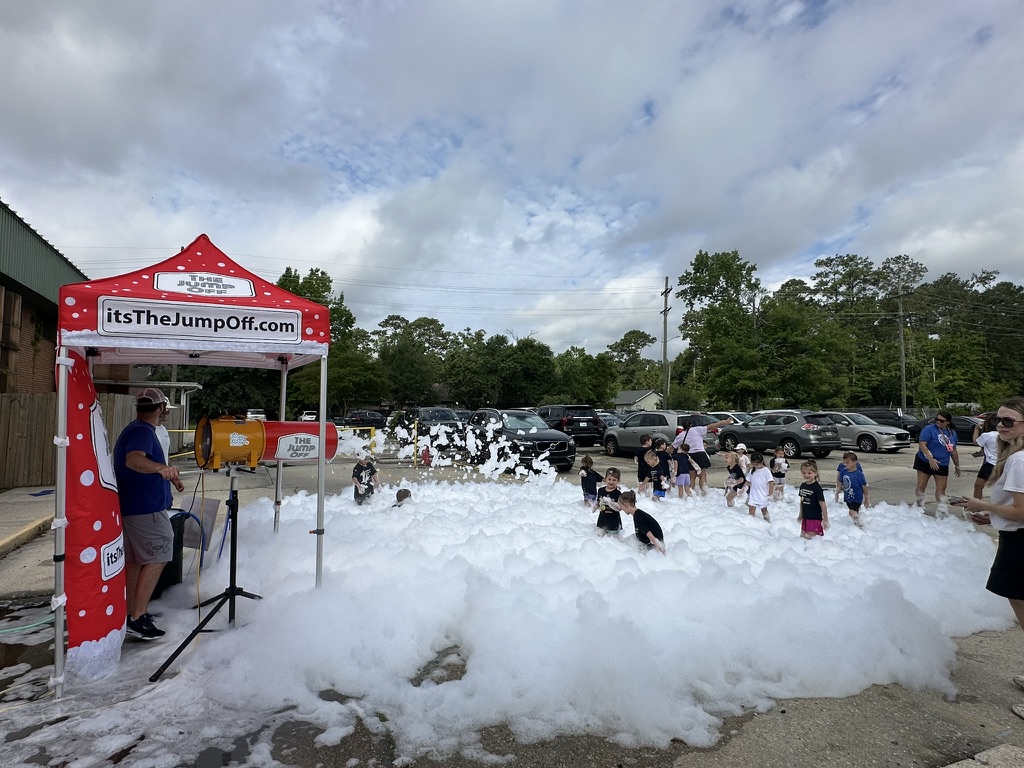 Foam party setup on hardscape near a tent in a parking lot area